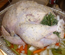 コイン状に切ったバターを皮と肉の間に。お腹にはローズマリー、レモンスライス